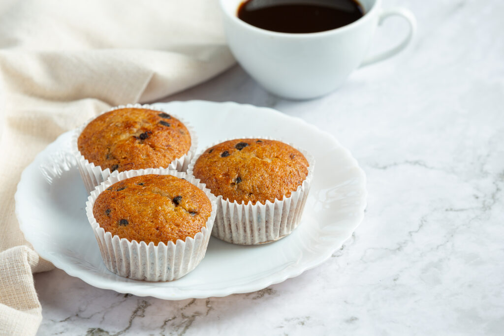 chocolate muffins put on round white plate with a cuo of coffee