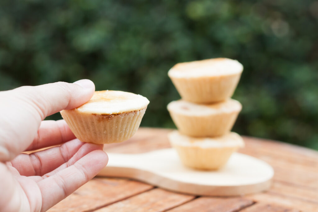 The Role Of Recyclable Muffin Cups In High Capacity Baking woman's hand holding mini pies