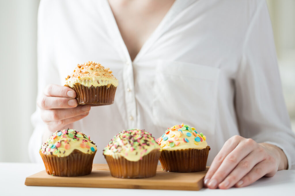Recyclable Muffin Cups That Support Quality Across All Baking Shifts close up of woman with glazed cupcakes or muffins