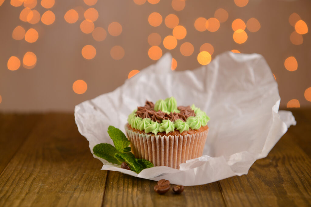Recyclable Muffin Cups That Deliver Reliable Results In Every Batch tasty cupcake with butter cream, on wooden table, on lights background