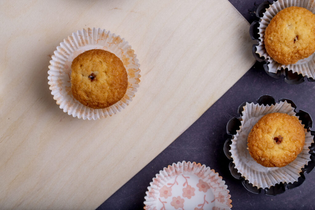 Recyclable Muffin Cups Designed For Reliable High Volume Baking top view of muffins in paper molds on rustic background